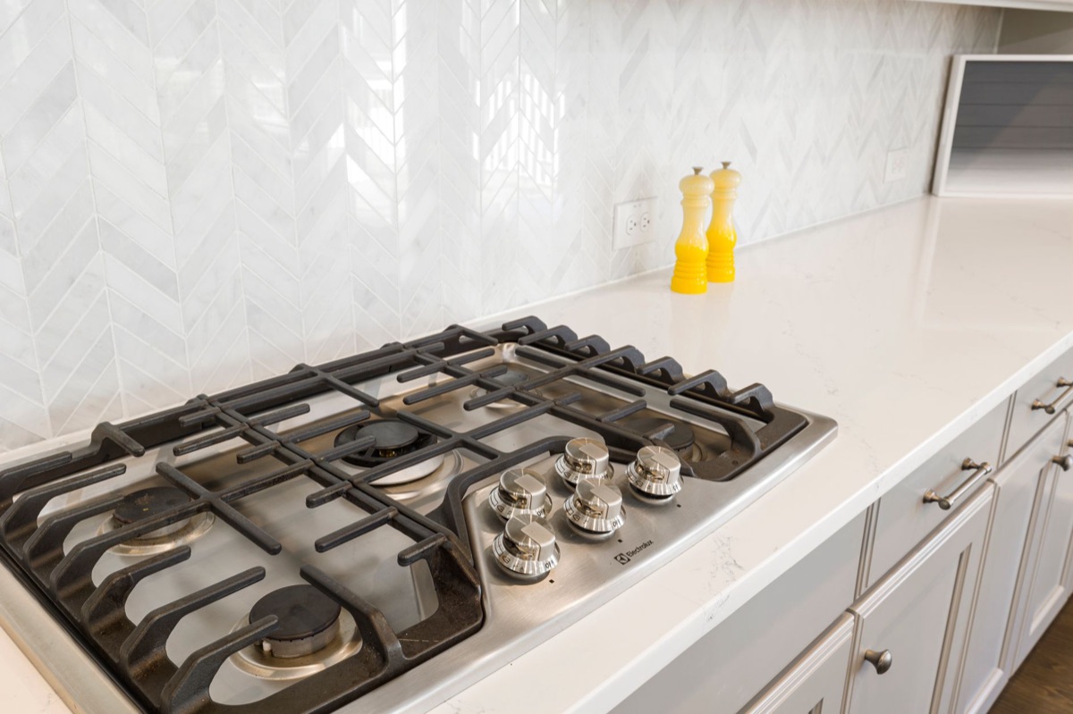 Close up of a stainless steel gas stove with oil residue