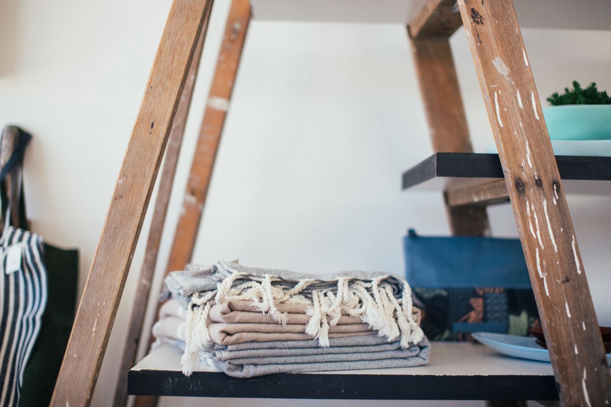 Piles de pulls en laine soigneusement pliés dans un tiroir.